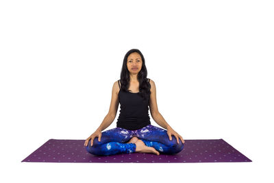 Portrait of a young woman sitting against white background