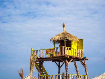 Low angle view of bird on roof against sky