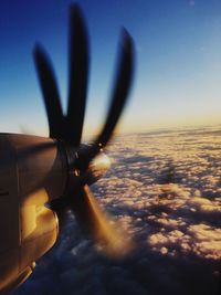 Close-up of airplane flying against sky during sunset