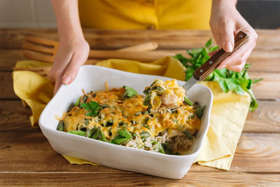 Fillet of chicken thigh with rice, cheese and soy sauce in a ceramic baking dish in the oven