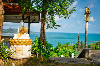 Statue by sea against sky