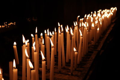 Panoramic shot of lit candles in temple against building