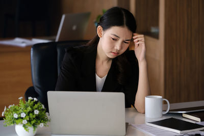 Businesswoman using laptop at table