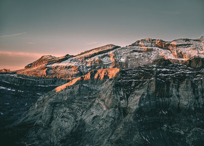 Rock formation on mountain against sky during sunset