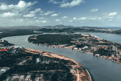 High angle view of city by sea against sky