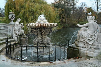 Statue by fountain in park