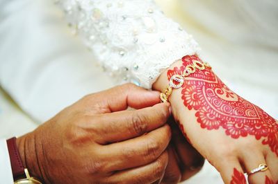 Cropped hands of bride and groom