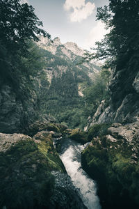 Scenic view of river amidst mountains against sky