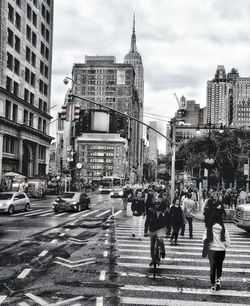 People walking on road in city against sky