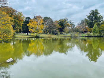 Scenic view of lake by trees against sky