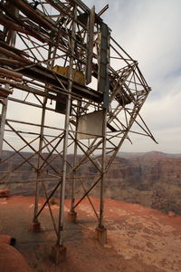 Metallic built structure on cliff against sky