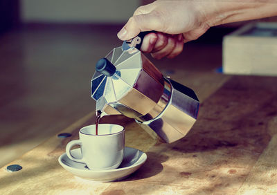 Close-up of hand holding coffee cup in cafe