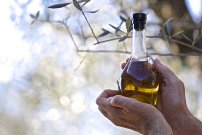 Close-up of hand holding glass bottle