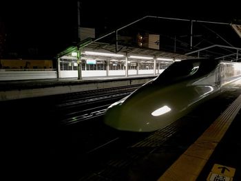 Train on railroad station platform at night