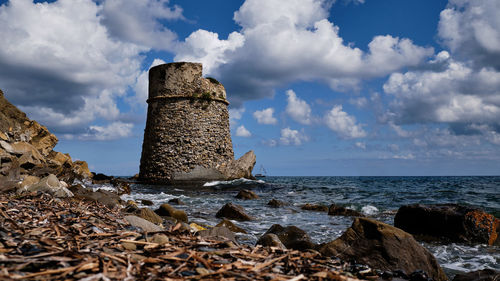 Rocks by sea against sky