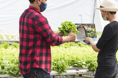 Close-up of buyer raising thumbs up on hydroponic vegetable farm. buying and selling vegetables. 