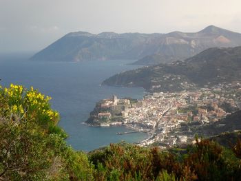 High angle view of city by sea against sky