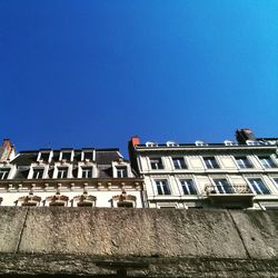 Low angle view of buildings against clear blue sky