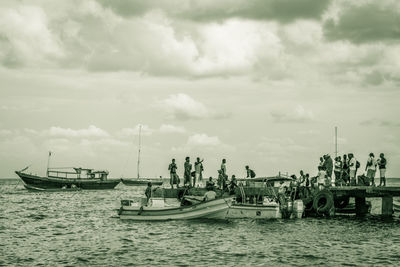 Boats moored in sea against sky