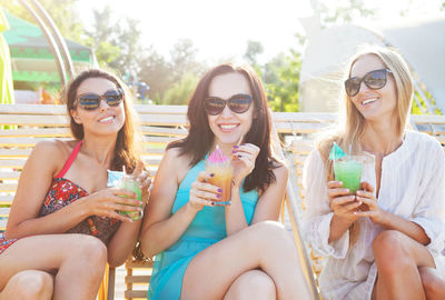 Portrait of smiling young woman sitting outdoors