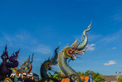 Low angle view of statue against blue sky