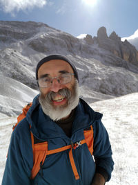 Portrait of young man standing against mountain