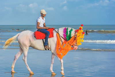 View of person riding horse on beach