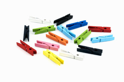 Multi colored clothespins over white background