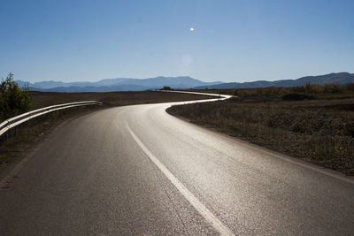 Empty road by mountain against sky