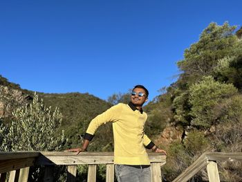 Side view of man standing against mountain