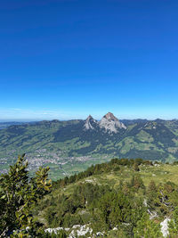 Scenic view of mountains against clear blue sky