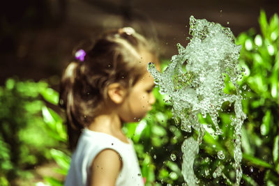 Close-up of wet girl with plants
