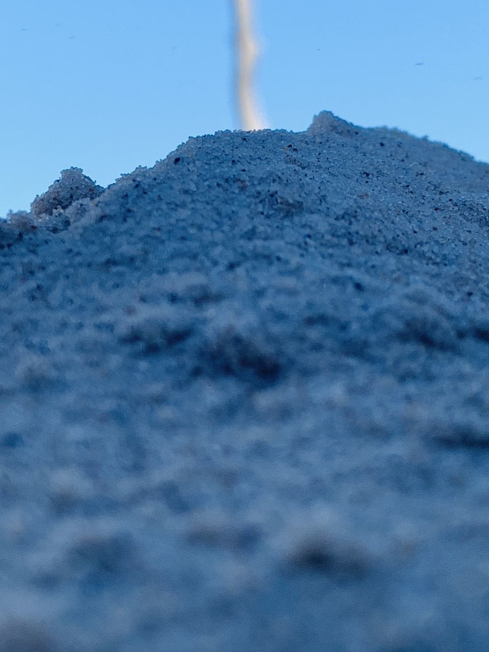 CLOSE-UP OF SNOW COVERED LAND AGAINST BLUE SKY