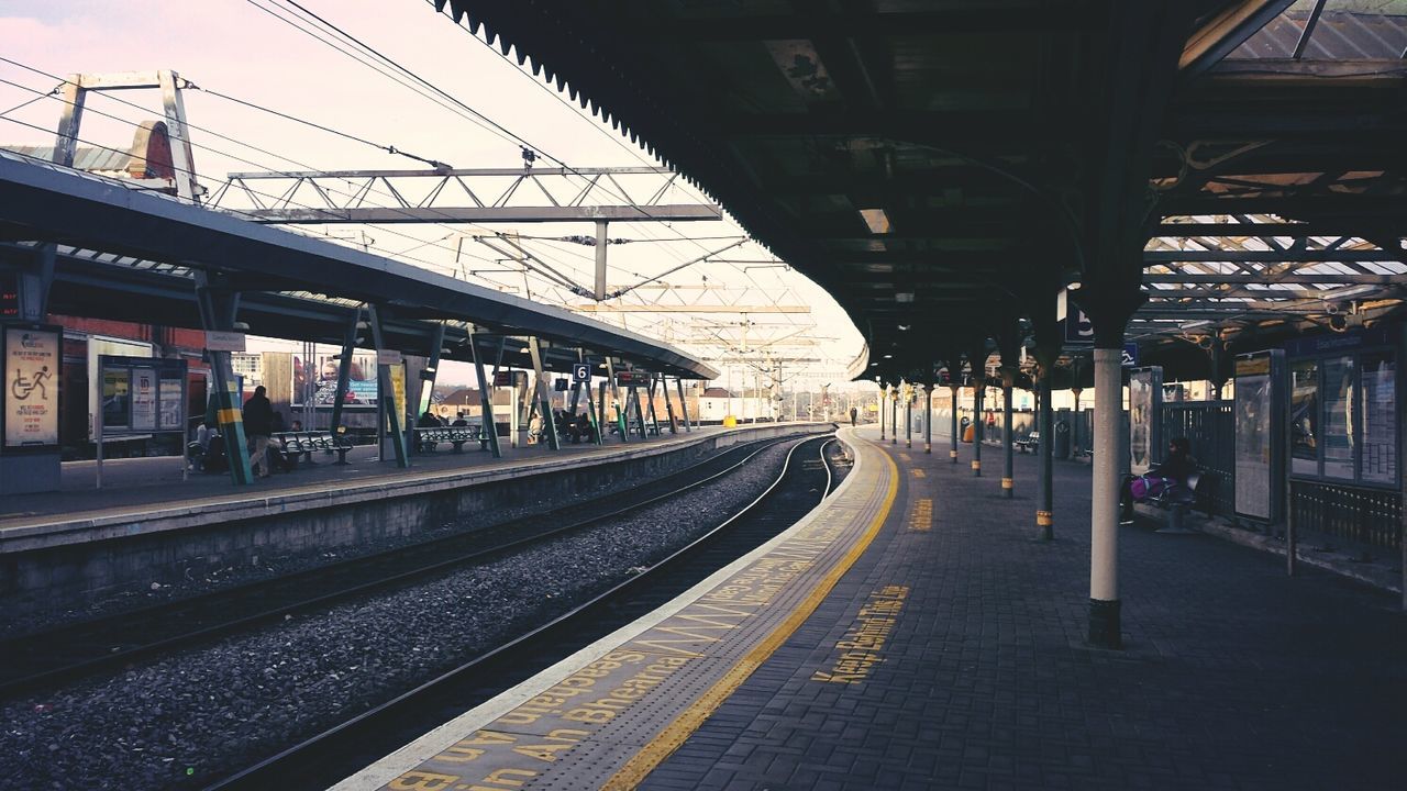 railroad track, transportation, rail transportation, railroad station platform, the way forward, railroad station, public transportation, built structure, architecture, diminishing perspective, vanishing point, empty, building exterior, long, train - vehicle, public transport, power line, incidental people, railway track, travel