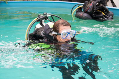 Woman learning underwater swimming with aqualung in pool