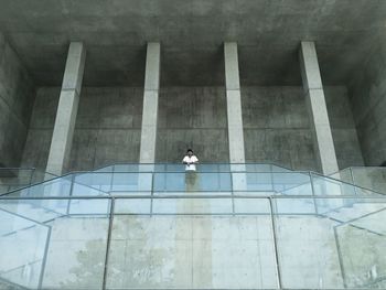 Low angle view of teenage boy leaning on railing in incomplete building