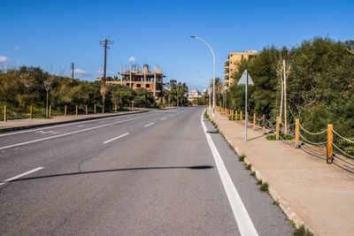 Empty road against clear blue sky