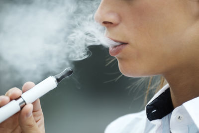 Close-up portrait of woman smoking cigarette