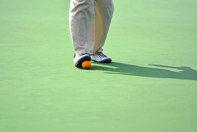 Low section of man playing lawn bowling at playing field