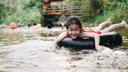 Happy girl relaxing on inflatable ring floating in lake