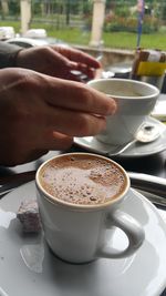 Close-up of hand holding coffee cup