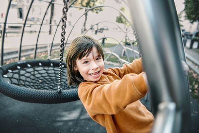 Side view of boy standing in car