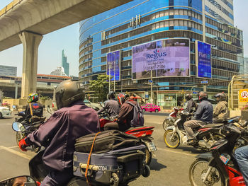 Rear view of people on street against buildings in city