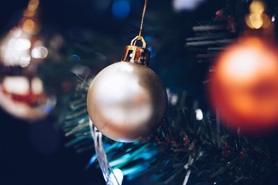 Close-up of baubles on illuminated christmas tree at night