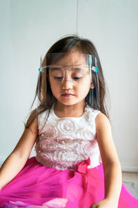 A toddler girl wearing the face protection shield. a safety corona mask during covid-19 pandemic.