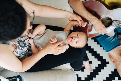 High angle view of young parents with their baby relaxing at home