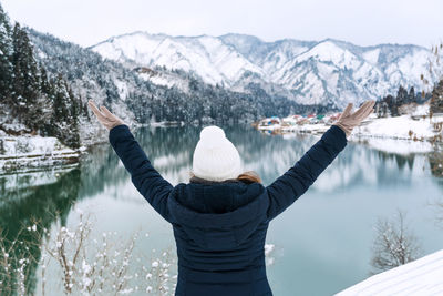 Rear view of woman looking at snowcapped mountain