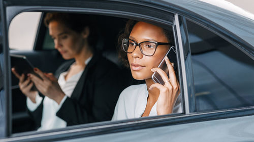 Close-up of businesswoman talking on mobile phone in car
