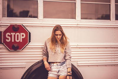 Portrait of woman standing against bus