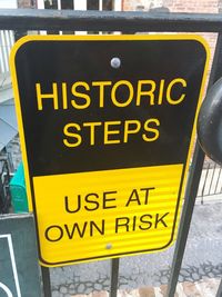 Close-up of yellow sign on road